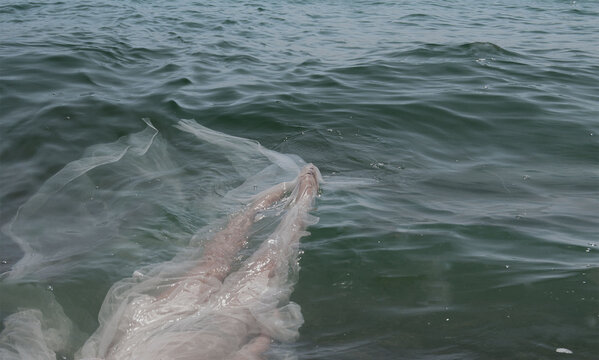 Woman wearing a dress floating in sea