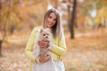 young beautiful woman with dog  in the autumn outdoor
