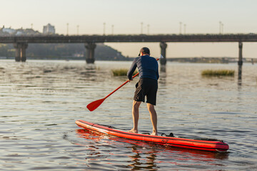 one man on stand up board swimm fast