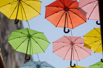 Fototapeta na wymiar Close up of many colorful umbrellas hanged under the blue sky 