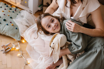 Mother and daughter spend time together. Mother's love. Teenager girl children's room. Hugs and care. mom and 10-year-old girl. Christmas Eve. Lifestyle real emotions. Childhood and parenting. Trust