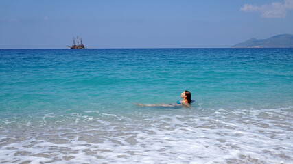 Fototapeta na wymiar a girl swims in the blue sea 