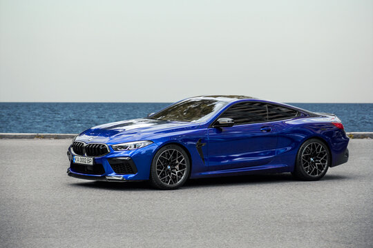 Kiev, Ukraine - June 19, 2021: Fast car BMW M8 on the road, against the background of the sea and sky