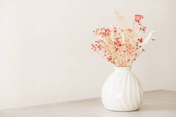 Modern dryed flowers bouquet in beige vase. Interior elegant home decor. Minimal floral...