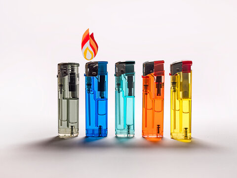 Row of multi coloured disposable lighters and a Conceptual flame