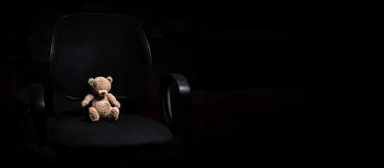 Teddy bear on an office chair.