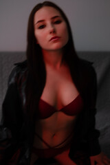 portrait of brunette woman in red underwear in dark grey room