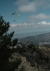 Vertical shot of a paraglider over rocky mountain tops