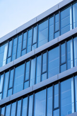 Fototapeta na wymiar Modern glazed building against a blue sky, Modern urban architecture