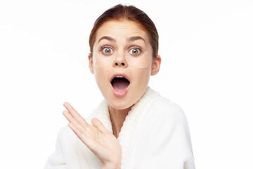 Woman in white robe posing fun skin care patches on face