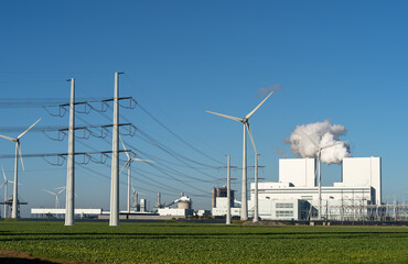 Fossil fuel (coal) power station, wind turbines and solar panels in the Eemshaven generating...