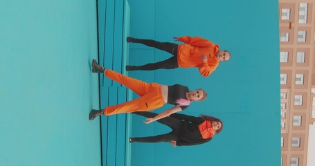 Dancing people team filming dance on phone outdoor. Stylish dancers record vertical video content for social network
