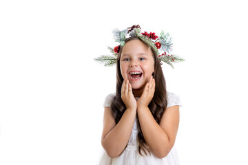 Obraz na płótnie Canvas portrait of laughing, excited girl in Christmas wreath and in white festive dress holding hands to face with amazement, isolated on white background. 