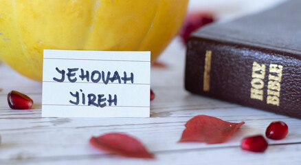 Jehovah Jireh, a handwritten name of God with Holy Bible book, pumpkin, and fall red leaves. The...