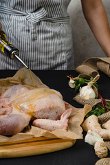 process cooking chicken legs with spices hot pepper ginger garlic greens on black background with woman