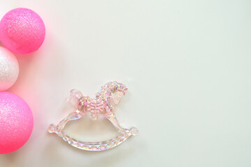 Christmas decoration crystal rocking horse and pink balls lies on the table