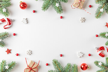 Christmas frame made of fir tree, gift boxes, decorations on white background. Flat lay. Top view