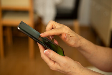 Older woman holding smartphone in hand