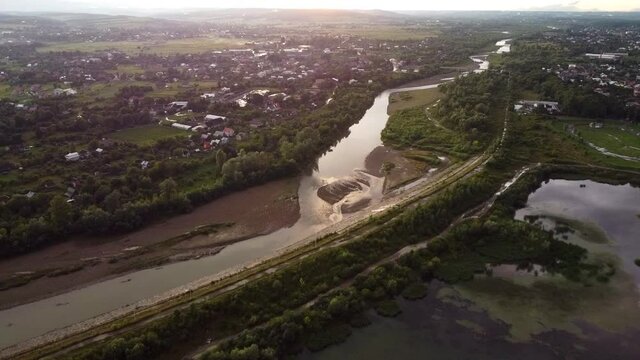 View of the Shevchenko lake in the park in Kolomyia. The Prut river in the distance. Trees and water. Drone Video. Ukraine. Europe