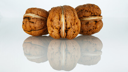 Arrangement of three walnuts on a white background