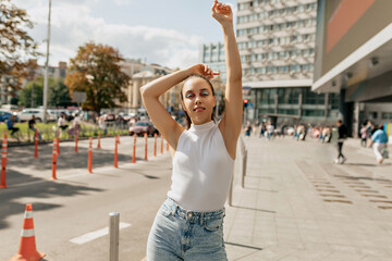 Outdoor portrait of stylish woman with bright make up in casual clothes is posing over urban city. Street style look. Autumn mood.