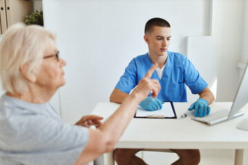 Obraz na płótnie Canvas elderly woman patient talking to doctor health care