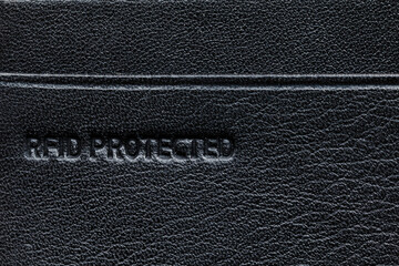 Black leather card holder with RFID protection. Macrophotography, flat lay.