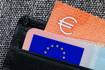ID card with European Union sign and a corner of Euro banknote in leather wallet, macrophotography