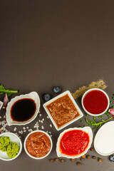 Fototapeta na wymiar Set of different sauces - ketchup, mayonnaise, barbecue, soy, chutney, wasabi, adjika, horseradish