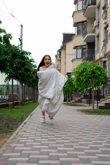 pretty brunette woman in white blanket outdoors. crazy rebel millennial girl