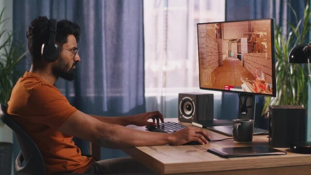 Indian gamer playing shooter at home