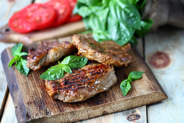 Grilled juicy steak on a wooden board.