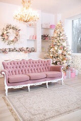 Warm cozy beautiful modern design of the room with fireplace in delicate light colors decorated with Christmas tree and decorative elements. Xmas interior