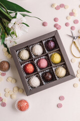 Set of healthy handmade chocolate candies in box and flowers. Cheese truffles. Sweet gift for Woman's Day, birthday or Mother's Day. Set of 9 candies