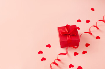 red ring box on pink background with hearts and ribbon