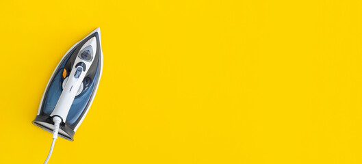 Blue electric iron on yellow background