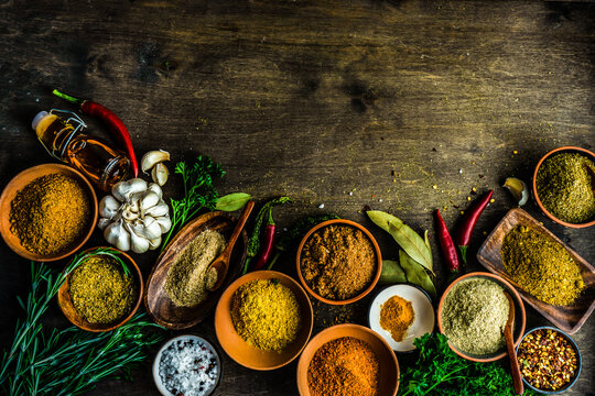 Arrangement of assorted fresh and dried herbs and spices on a wooden table