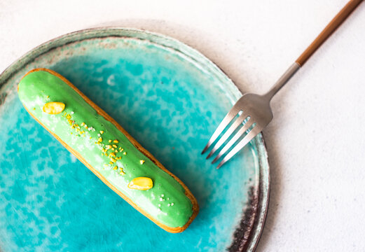 Overhead view of a pistachio eclair on a plate