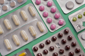 plates with different tablets and capsules on a green background