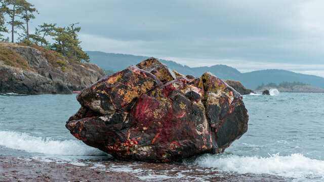 Large rock boulder on a beach on Pender Island, British Columbia during a grey stormy day