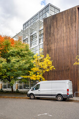 Compact cargo mini van delivered goods to client at multi-apartment high-rise building with wood...