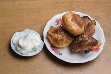 profiteroles and plate with sweet cream on wooden table. Top view