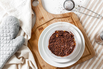 Carrot and chocolate jar cake vintage composition with oven glove, cutting board, kitchen cloth and cinnamon powder. Food concept.