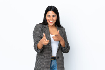 Young latin woman woman isolated on white background pointing to the front and smiling