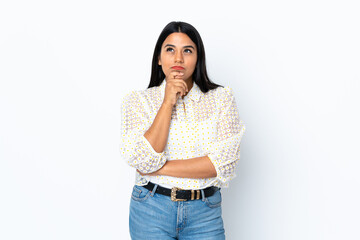 Young latin woman woman isolated on white background having doubts while looking up