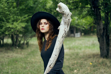 woman in black witch costume in forest nature posing