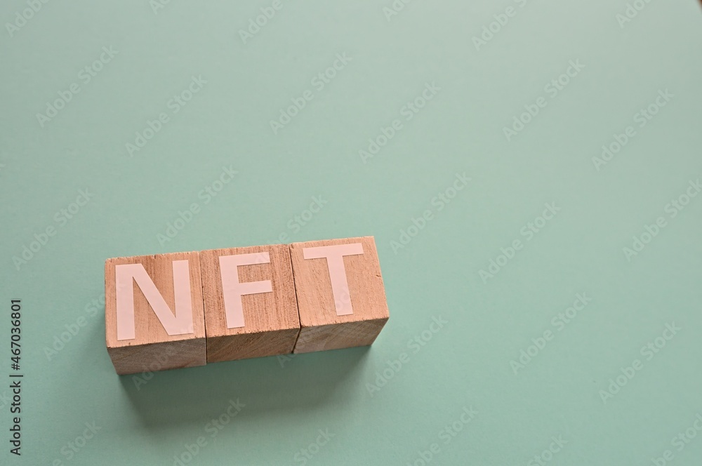 Poster the cubes arranged in the word nft it's an abbreviation for non-fungible token. copy space available