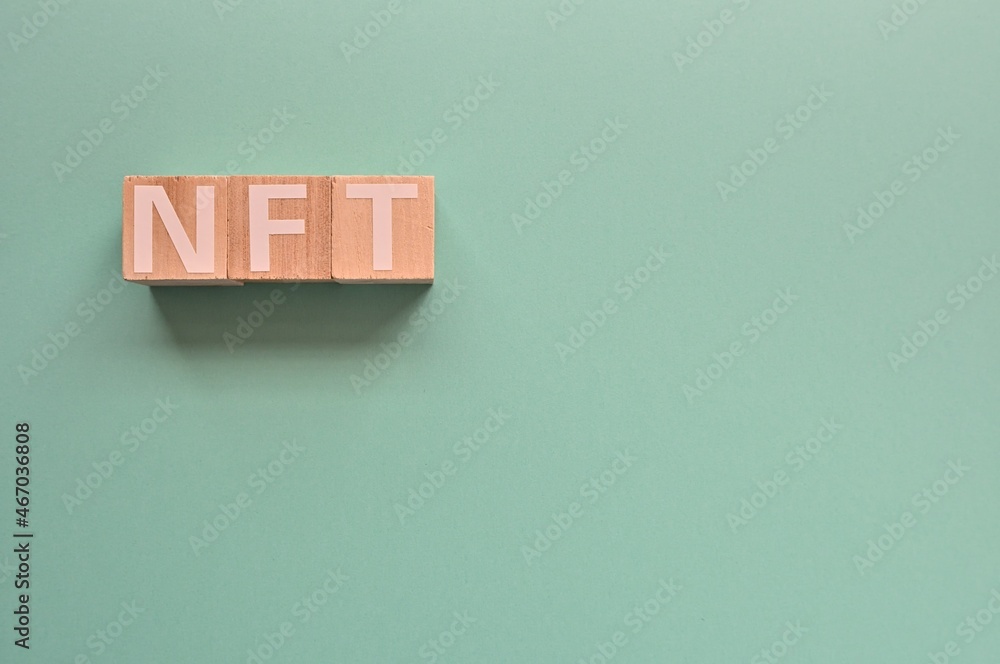 Poster the cubes arranged in the word nft it's an abbreviation for non-fungible token. copy space available