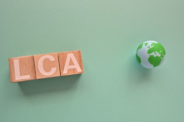 The letters arranged in the word LCA It's an abbreviation for Life Cycle Assessment with a ball of...
