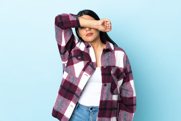 Young latin woman woman isolated on blue background covering eyes by hands